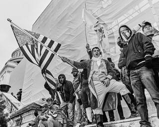 Group of protestors waving American flags outside a building