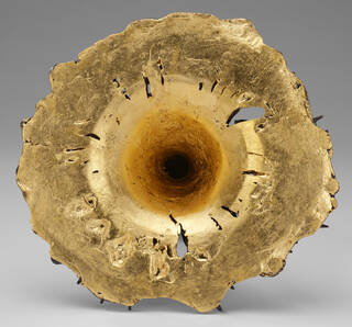 Gold base of sculpture with hole in the middle