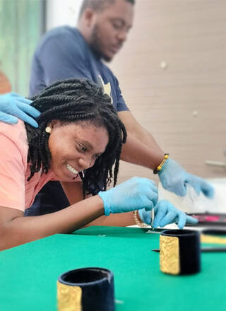 woman wearing blue gloves working at a table with green top