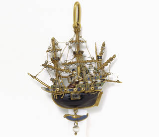 Pendant in the shape of a ship. Wooden hull mounted in enamelled gold, the rigging strung with pearls.