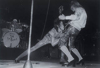 Black and white photograph of David Bowie as Ziggy Stardust on stage 