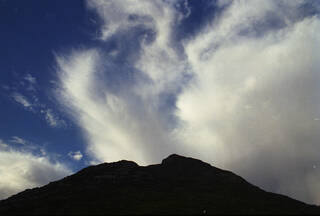 Landscape photograph of mountain with blue sky and white clouds