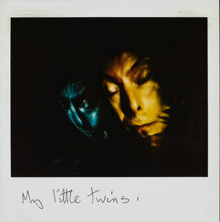 Polaroid photograph of a Bowie puppet head annotated by David Bowie with words 'My little twins'