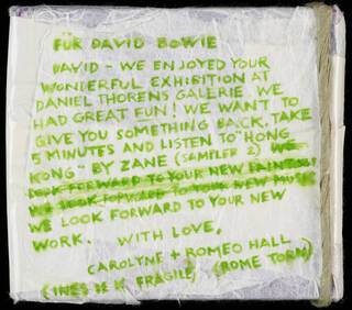 Hand-written note in green pen on white paper