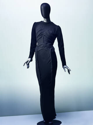black dress on a grey mannequin. Dress has a skeleton 3D design sewn onto it