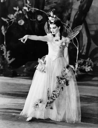 Black and white photograph of a woman in white costume on stage
