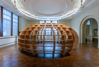 Photograph of a large round wooden structure with slatted walls 