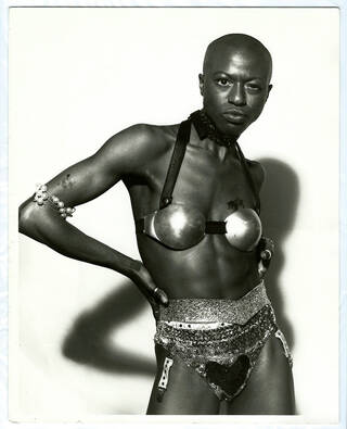 Black and white photo of a woman in sequinned and metal bra and pants