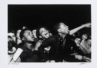 Black and white photo of crowd at a concert with their mouths open