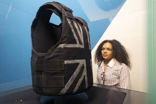 A woman look at a stab vest with a union jack