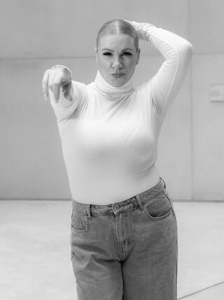 Black and white photo of a woman pointing directly at the camera