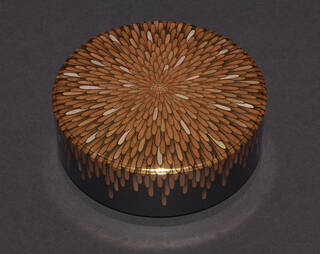 Round box with glittering flower motif on lid